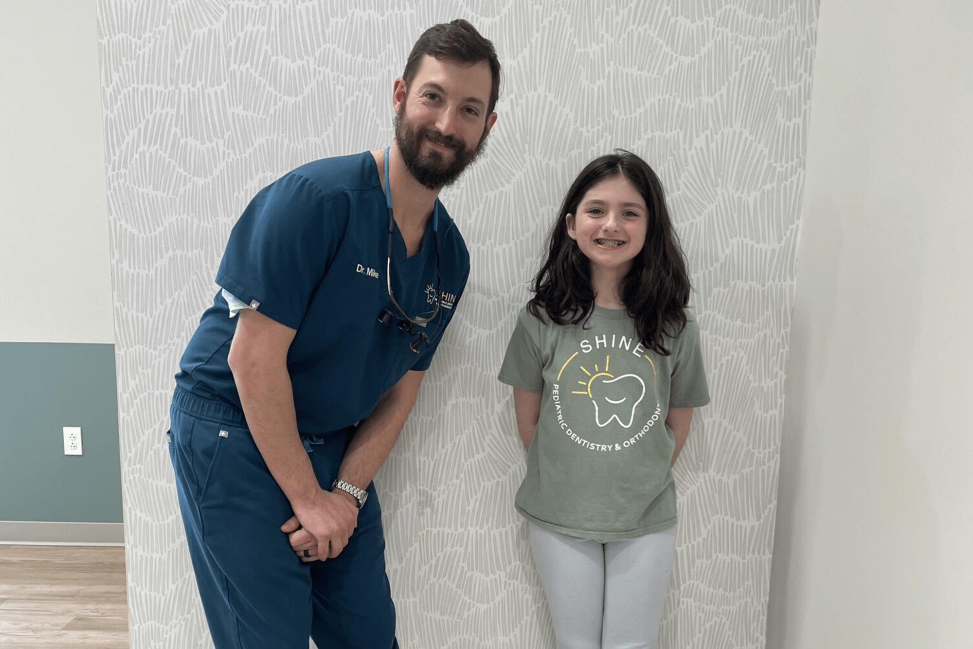 little girl smiling next to doctor